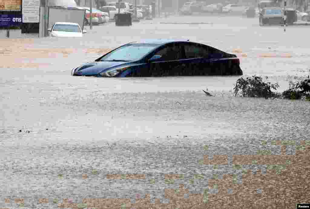 A car is partially submerged on a flooded street as Cyclone Shaheen makes landfall in Muscat Oman, Oct. 3, 2021.