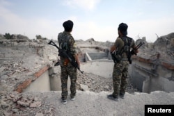 Fighters from Syrian Democratic Forces (SDF) stand near destroyed Uwais al-Qarni shrine in Raqqa, Syria, Sept. 16, 2017.