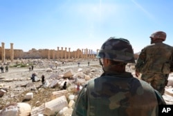Soldiers look over damage at the historical Bel Temple in the ancient city of Palmyra in Homs, Syria in April 2016.