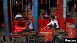 Vendors sort onions at a wholesale vegetable market in Kolkata, Sept. 18, 2013. 