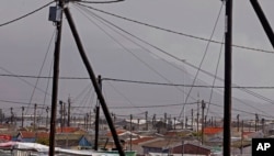 FILE - A view of electrical poles and wires at a suburb, with Table Mountain in backdrop, near the city of Cape Town, South Africa, Sept. 27, 2013.