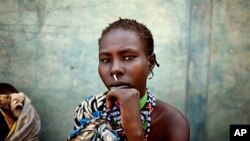 A woman from the Murle tribe awaits food distribution in the town of Pibor, South Sudan, February 2, 2012. The Murle of South Sudan's Jonglei State, have been involved in fierce tribal violence with the neighboring Lou Nuer tribe. The two groups have long