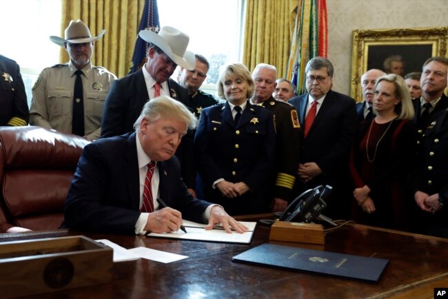 FILE - President Donald Trump signs the first veto of his presidency in the Oval Office of the White House, March 15, 2019, in Washington. Trump issued the veto to protect his emergency declaration for border wall funding.