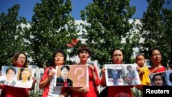 被拘押的中国维权律师家属在北京最高人民检察院前举牌抗议。（资料照片）