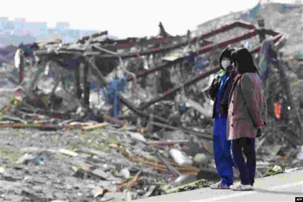 People look at a devastated area of Minamisanriku, northern Japan, Monday, March 14, 2011, three days after a powerful earthquake-triggered tsunami hit the country's east coast. (AP Photo/The Yumiuri Shimbun, Tsuyoshi Matsumoto) JAPAN OUT, CREDIT MANDATOR