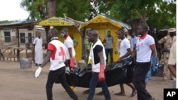 Red cross officials carry a body at the site of a bomb explosion in Maiduguri, Nigeria, Friday, July 31, 2015. 