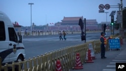 China Tiananmen Anniversary: A pair of late-arriving visitors run to watch the daily flag-raising ceremony at dawn at Tiananmen Square in Beijing, Saturday, June 4, 2016.