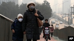 지난 20일 스모그가 짙은 중국 베이징 거리에서 시민들이 마스크를 하고 있다.