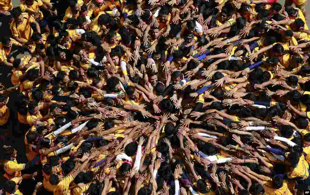 Indian youth form a human pyramid to break the &quot;Dahi handi,&quot; an earthen pot filled with curd hanging above, to mark Janmashtami festival in Mumbai. 