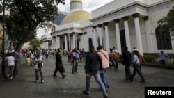 FILE - People walk past the National Assembly building in Caracas, Venezuela, Dec. 22, 2015.