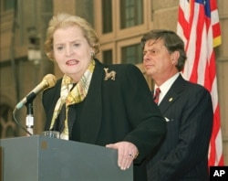 1997年2月24日，美国国务卿奥尔布赖特在北京对美国驻华使馆工作人员发表讲话，美国驻华大使尚慕杰(右)在场