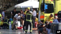 스페인 바르셀로나 유명 관광지인 라스 람블라스 구역에서 17일 차량이 돌진 사건이 발생한 후 구조대가 부상자들에 응급처치를 하고 있다.