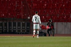 Cristiano Ronaldo dari Portugal memegang armband kaptennya (kanan), sebelum melemparnya ke tanah dengan marah, saat pertandingan sepak bola kualifikasi grup A Piala Dunia 2022 melawan Serbia, di stadion Rajko Mitic di Beograd, Serbia, Sabtu, 27 Maret 2021.