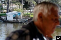 FILE - An abandoned fishing boat is seen sitting on the bank of a bayou past seafood dock owner Price Billiot in the Native American fishing village of Pointe-Aux-Chenes, La., devastated after a 2010 oil spill in the Gulf of Mexico.