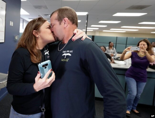 Former felon Brett DuVall, right, kisses his wife Dottie as they celebrate after he registered to vote at the Supervisor of Elections office, Jan. 8, 2019, in Orlando.