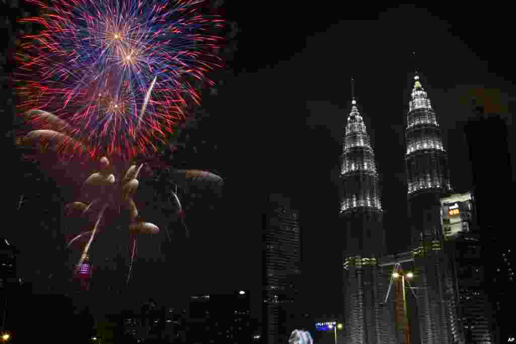 Fuegos artificiales explotan frente al edificio emblemático de Malasia, Petronas Twin Towers, durante la celebración de la víspera de Año Nuevo en Kuala Lumpur, Malasia. (Foto AP)