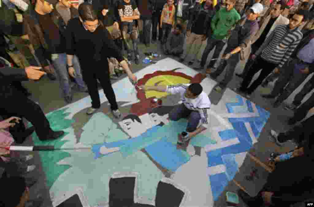 Artists paint political street art on the road at the continuing anti-government demonstration in Tahrir Square in downtown Cairo, Egypt Wednesday, Feb. 9, 2011. Tahrir Square has witnessed an explosion of political expression and free speech since the an