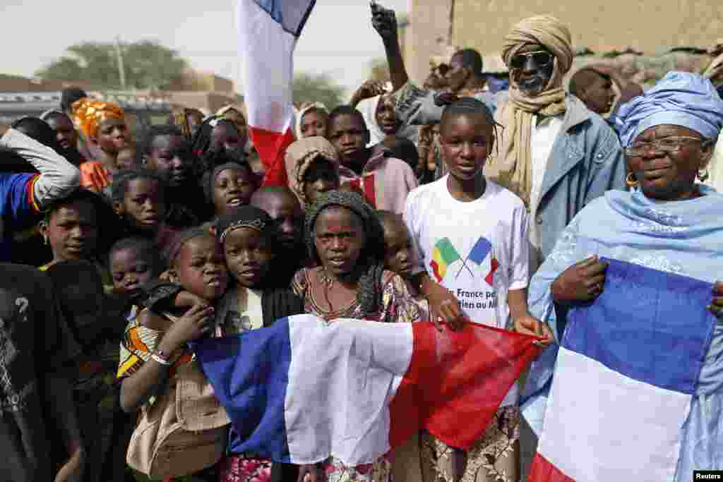 Children celebrate holding a French flag during the reopening ceremony of Mahamane Fondogoumo elementary school in the town center of Timbuktu February 1, 2013.