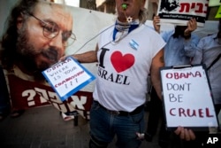 FILE - Israeli protesters hold posters demanding the release of Jonathan Pollard, a Jewish American who was jailed for life in 1987 on charges of spying on the United States, as they stand outside the U.S. Embassy in Tel Aviv, Israel, June 19, 2011.