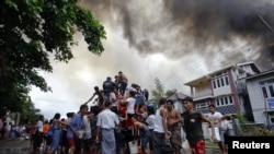 Warga di negara bagian Rakhine mengambil air dari truk pemadam kebakaran untuk memadamkan kebakaran rumahnya dalam bentrokan antara ummat Budha dan muslim Rohingya (10/6). 