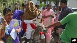 FILE—An Indian Christian devotee dressed like Jesus Christ sits on a donkey as others hold palm leaves during a Palm Sunday procession in Hyderabad, India, March 20, 2016.