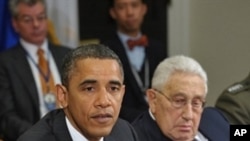 President Barack Obama speaks during a meeting about the new START Treaty in the Roosevelt Room of the White House in Washington as former Secretary of State Henry Kissinger (r) looks on, 18 Nov 2010