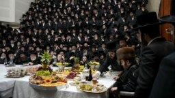 Ultra-Orthodox Jews of the Sadigura Hasidic dynasty celebrate the Jewish feast of 'Tu Bishvat' or "New Year of the Trees." as they sit with their rabbis around a long table filled with all kinds of fruits, in the ultra-Orthodox town of Bnei Brak, Israel, 