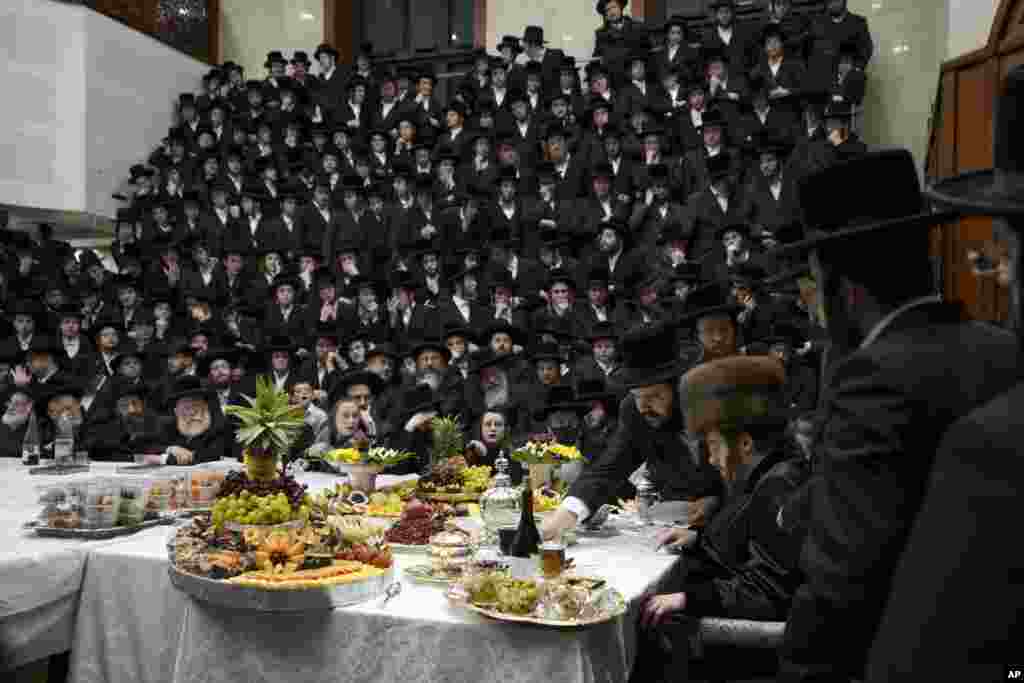 Ultra-Orthodox Jews of the Sadigura Hasidic dynasty celebrate the Jewish feast of &#39;Tu Bishvat&#39; or &quot;New Year of the Trees.&quot; as they sit with their rabbis around a long table filled with fruits, in the ultra-Orthodox town of Bnei Brak, Israel, Jan. 16, 2022.