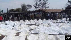 UN Peacekeepers and medics stand beside the bagged bodies of victims of an oil tanker explosion in Sange, Democratic Republic of Congo, 03 Jul 2010