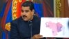 El presidente de Venezuela, Nicolás Maduro, sostiene un mapa de Venezuela con las regiones resaltadas en rojo donde los candidatos progubernamentales obtuvieron la victoria en una conferencia de prensa en Caracas. Octubre 17, 2017.