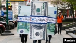 People dressed as blocks of currency notes walk along a street as part of a marketing campaign in Moscow, April 28, 2014.