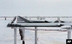 FILE - Ice forms on pipelines built near the Colville-Delta 5 drilling site on Alaska's North Slope, Feb. 9, 2016.