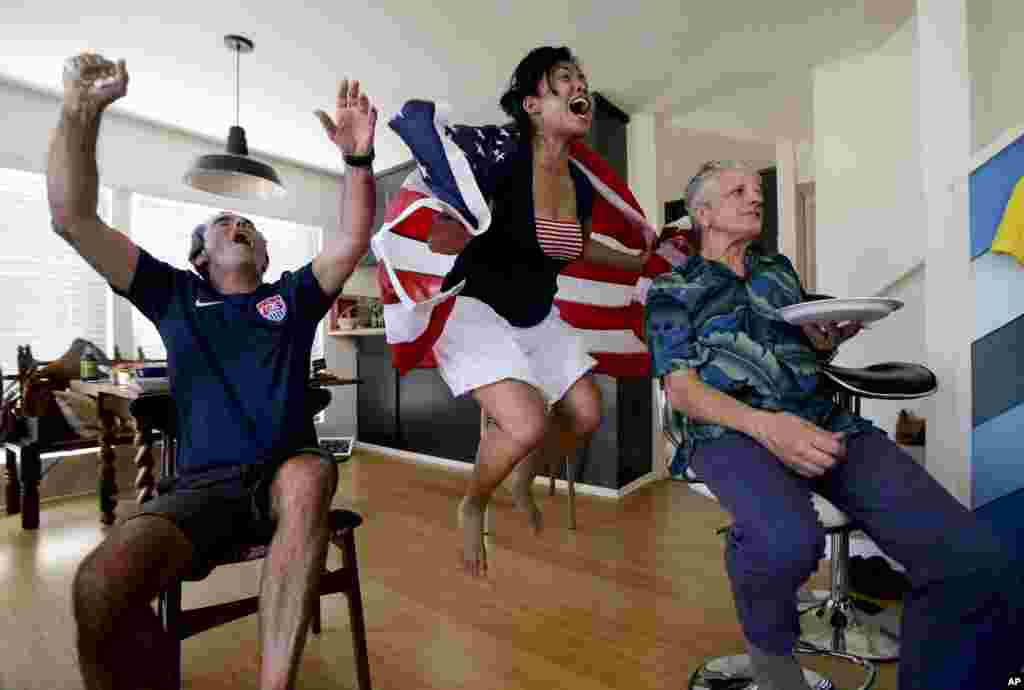 Ed Pollard, from left, Tina Termsomket and John Courte react after Portugal scored against USA during the first half while watching a televised group G World Cup soccer match in in Newport Beach, California, June 22, 2014.
