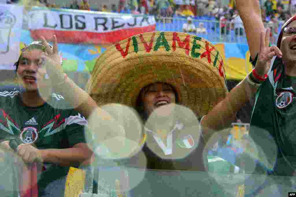 Mexican football fans cheer for their team during the Group A football match between Mexico and Cameroon at the Dunas Arena in Natal, Brazil, during the 2014 FIFA World Cup.