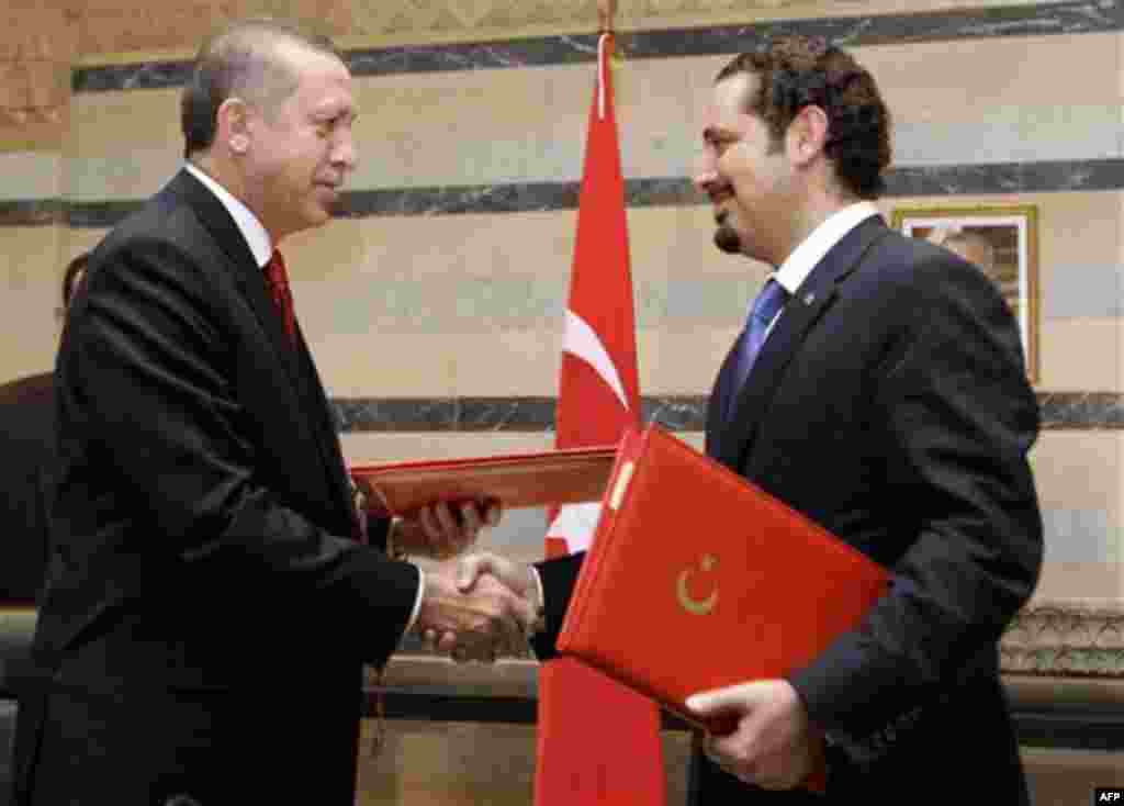 Lebanese Prime Minister Saad Hariri, right, exchanges signed agreements with his Turkish counterpart Recep Tayyip Erdogan, left, at the Government House in Beirut, Lebanon, Wednesday, Nov. 24, 2010. Erdogan arrived in Beirut on Wednesday on a two-day visi