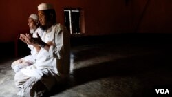 Rohingya refugees Hafez Sayed Alam and Faizul Karim (rear) pray inside Masjid Umar Bin Khattab mosque at Kutupalong refugee camp April 2, 2019. (Hai Do/VOA)