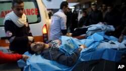 Palestinian medics a wounded youth, who was shot by Israeli troops during a protest at the Gaza Strip's border with Israel, into the treatment room of Shifa hospital in Gaza City, Friday, Jan. 11, 2019.