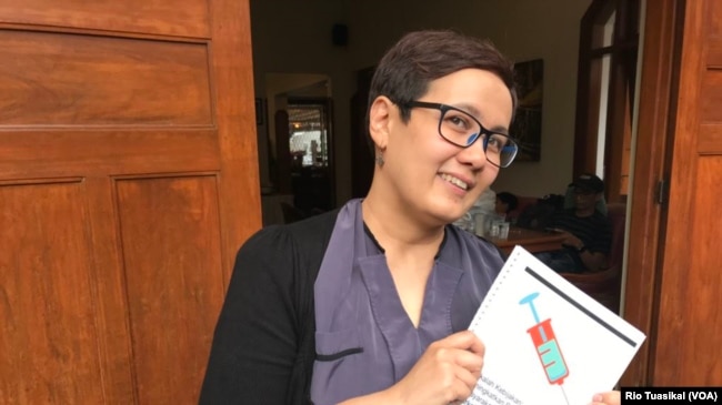 Peneliti Intuisi Inc, Ingrid Irawati Atmosukarto, memegang hasil kajian terhadap pendekatan perang terhadap narkoba. Ia mengusulkan pendekatan pengurangan dampak buruk atau "harm reduction." (foto: Rio Tuasikal/VOA)