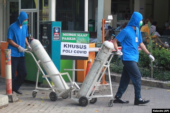 Para petugas mendorong tangki oksigen di RSUP Dr. Sardjito di Yogyakarta, Minggu, 4 Juli 2021. (Foto: Kalandra/AP Photo)