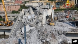 Firefighters remove rubble of the collapsed Morandi highway bridge, in Genoa, Italy, Aug. 18, 2018. 