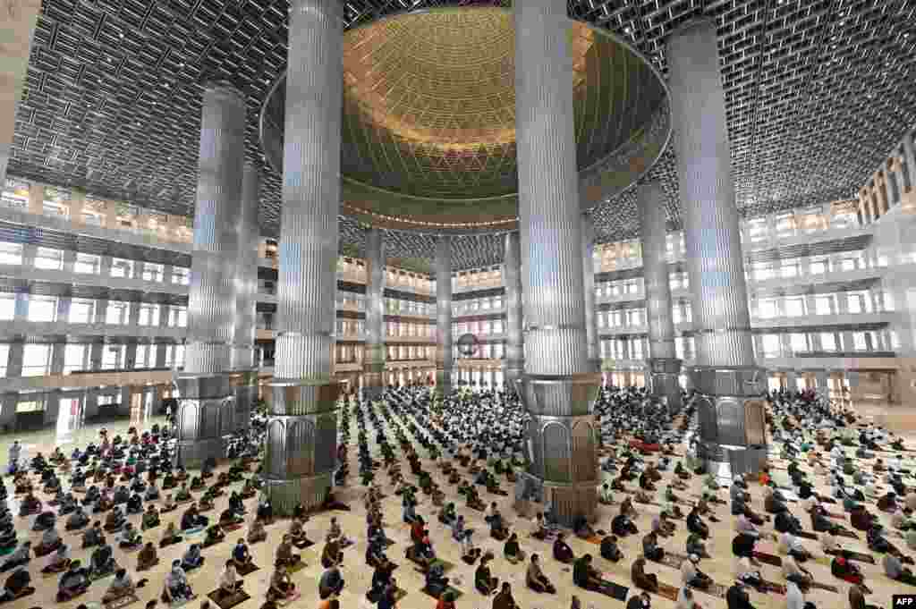 Muslim people conduct Friday prayers with physical distancing at the Istiqlal mosque in Jakarta, Indonesia.