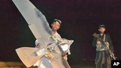 A Pakistani villager holds the wreckage of a suspected surveillance drone that crashed in Pakistani border town of Chaman along the Afghanistan border in Pakistan, August 2011. (file photo)