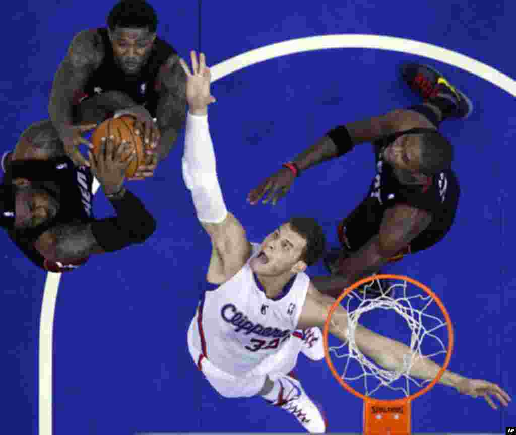 Los Angeles Clippers Blake Griffin (2nd R) fights for a rebound with Miami Heat's LeBron James (L-R), Udonis Haslem, and Chris Bosh during their NBA game in Los Angeles, California January 11, 2012.