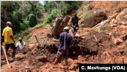 A family in Chimanimani digs, March 22, 2019, without protective clothing, for their missing 17-year-old nephew after Cyclone Idai hit the area. The body was found late Friday a week after he was trapped in his bedroom while asleep.