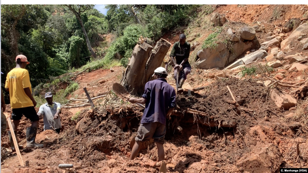 A family in Chimanimani digs, March 22, 2019, without protective clothing, for their missing 17-year-old nephew after Cyclone Idai hit the area. The body was found late Friday a week after he was trapped in his bedroom while asleep.