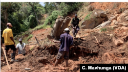 A family in Chimanimani digs, March 22, 2019, without protective clothing, for their missing 17-year-old nephew after Cyclone Idai hit the area. The body was found late Friday a week after he was trapped in his bedroom while asleep.