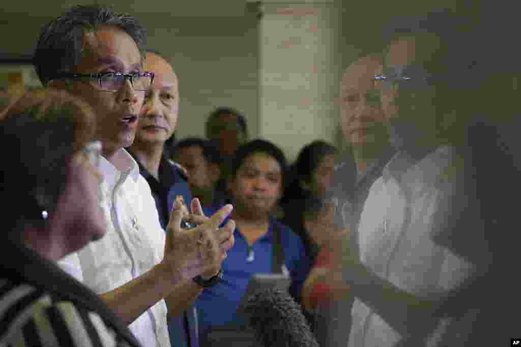 Interior Secretary Mar Roxas (second left) gestures as he answers questions from reporters about the surrender of Maria Kristina Sergio (not shown), the alleged boss of convicted Filipino drug trafficker Mary Jane Veloso. Sergio allegedly gave Veloso the bag that contained the heroin found by police at Yogyakarta airport, April 29, 2015.