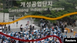 FILE- Protesters comprising of South Korean employers and employees working at factories in the Kaesong Industrial Complex (KIC) inside North Korean chant slogans during a rally at the Imjingak pavilion.