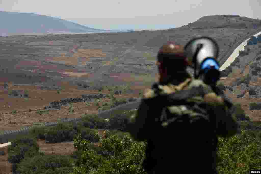 یک سرباز اسرائیلی با یک بلندگوی بزرگ پیام هایی را از بلندی های جولان به مردم در حاشیه این محل می دهد. این منطقه که به سوریه تعلق داشت، بعد از جنگ، در اشغال نیروهای اسرائیلی قرار گرفت.
