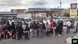 Gas customers on foot with portable containers and lines of vehicles wait for gas pumps to open at a service station, November 3, 2012 in the Brooklyn borough of New York. 
